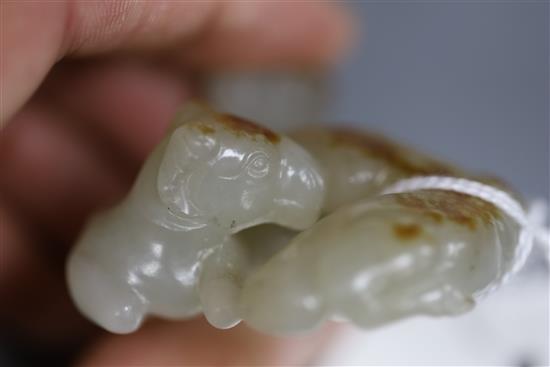A Chinese pale celadon and russet jade group of three goats, 19th/20th century, 5cm, wood stand